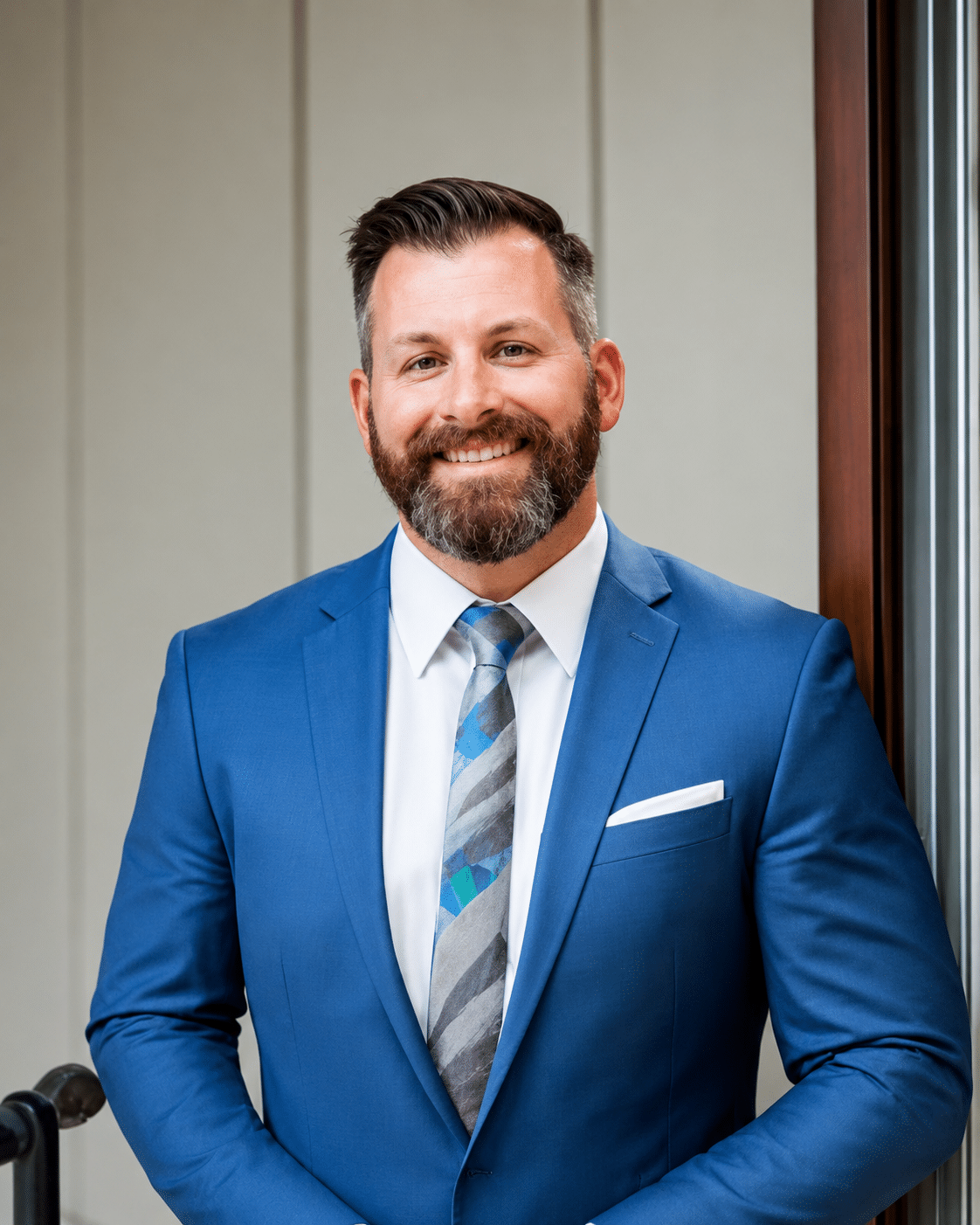 Dr. Austin Westover standing in a blue suit and patterned tie, smiling on the Meet the Doctors page at Charles Town Family Dentistry in Charles Town, WV