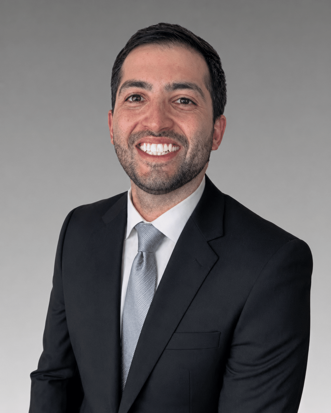 Dr. Kamran Waterman in a dark suit and tie, smiling in a professional headshot on the Meet the Doctors page at Charles Town Family Dentistry in Charles Town, WV